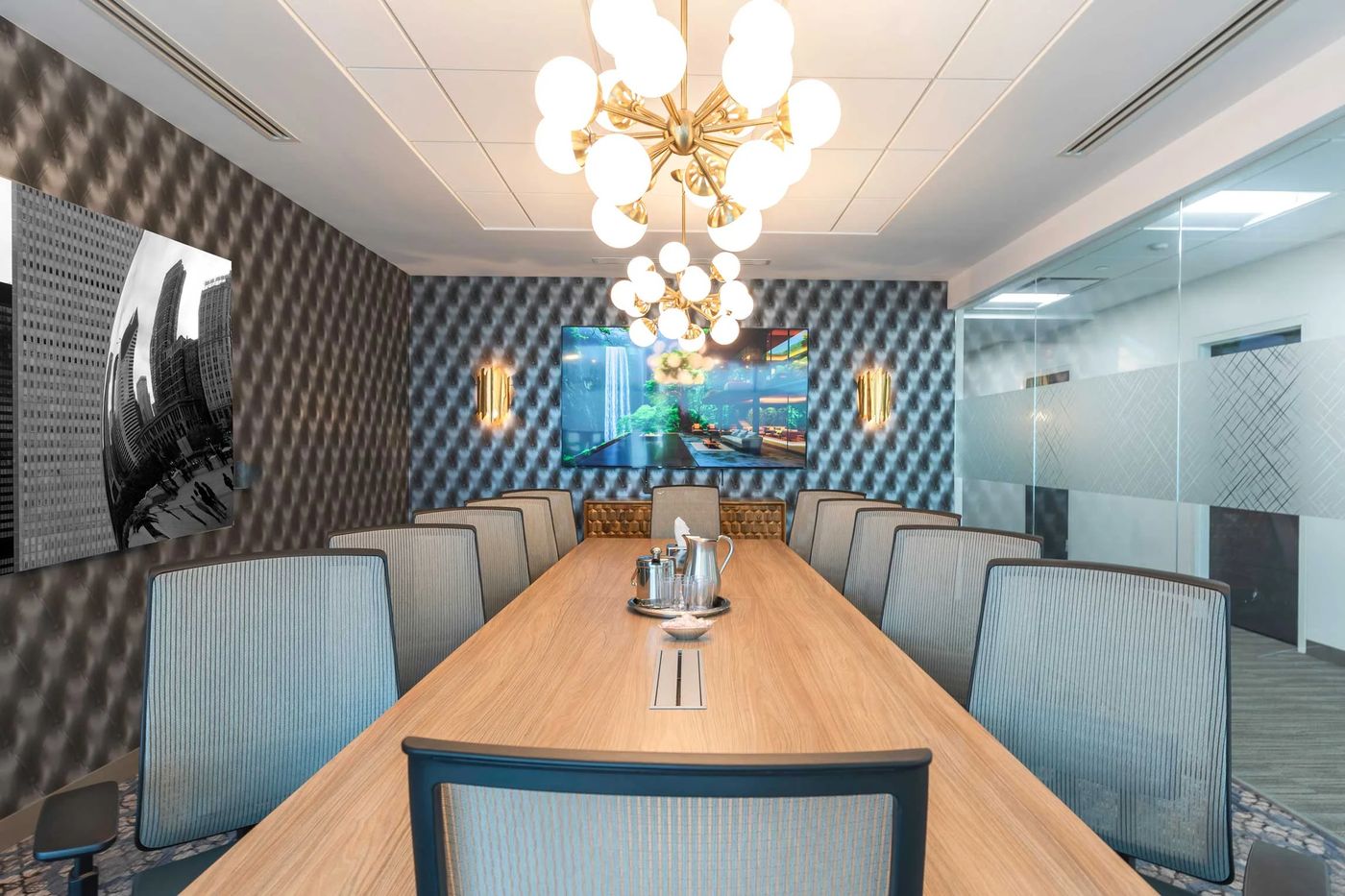 The conference room, with a long wooden table under gold chandeliers